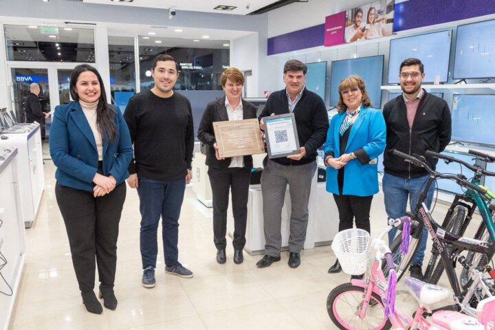 Los secretarios del Gabinete municipal Gonzalo Ferro y Alejandra Arce, acompañada del subsecretario de Innovación y Gestión y concejal electo Jonatan Bogado, entregan un reconocimiento del intendente Martín Pérez a los ejecutivos de Frávega.